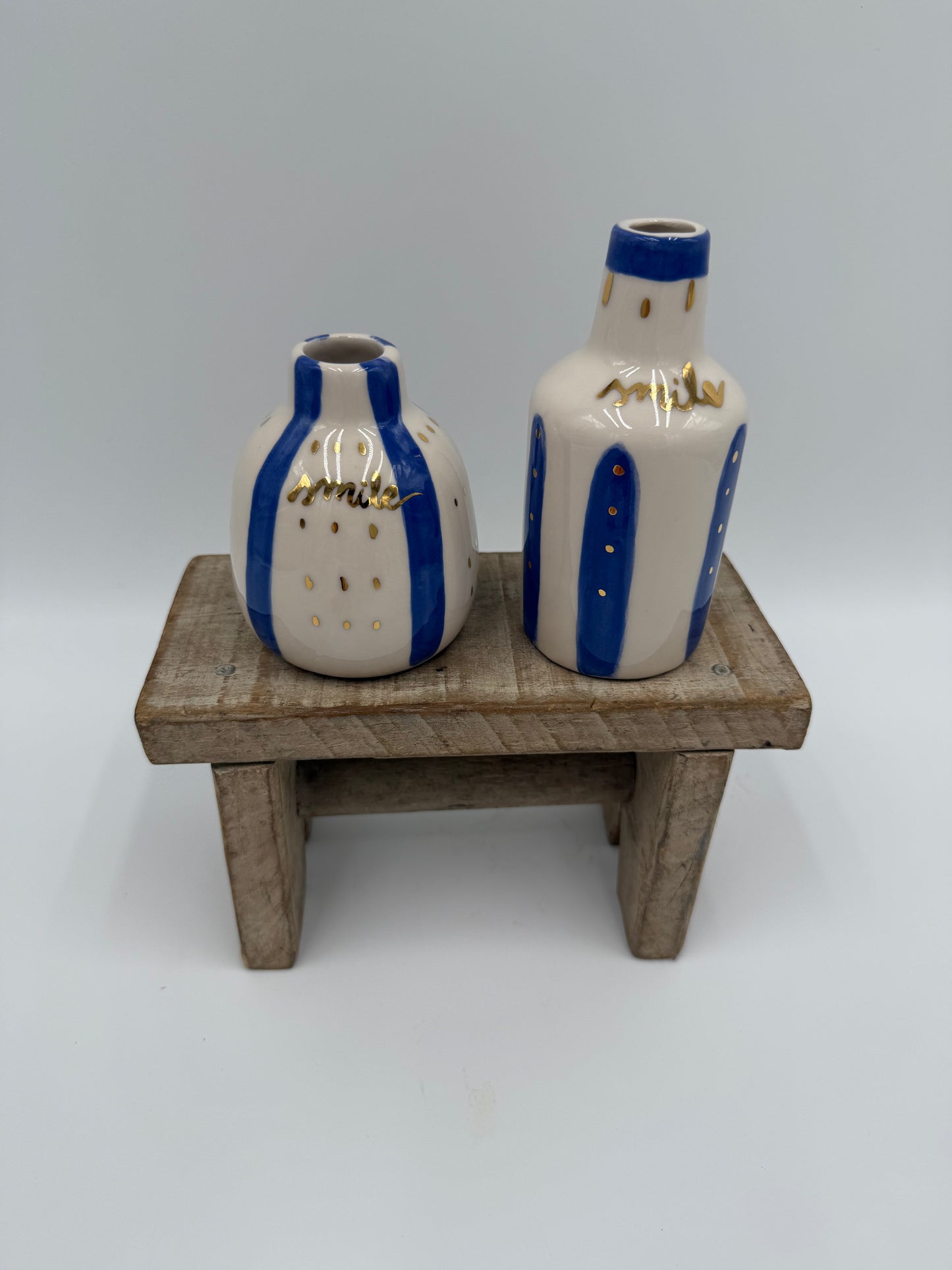 BOTELLITAS DE CERÁMICA BLANCA Y AZUL CILÍNDRICA TOQUES DORADOS